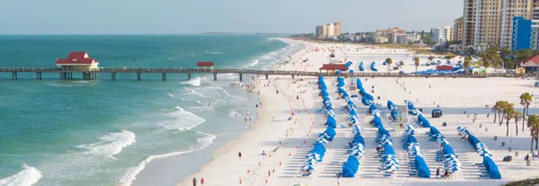 beach with blue beach chairs and beach umbrellas